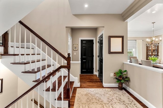 entrance foyer featuring stairs, wood finished floors, baseboards, an inviting chandelier, and recessed lighting