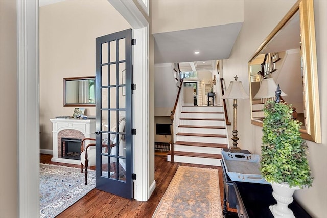 stairs featuring baseboards, a fireplace, and wood finished floors
