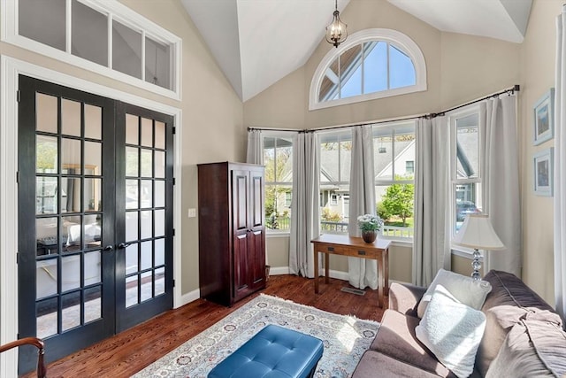 interior space with french doors, baseboards, wood finished floors, and high vaulted ceiling