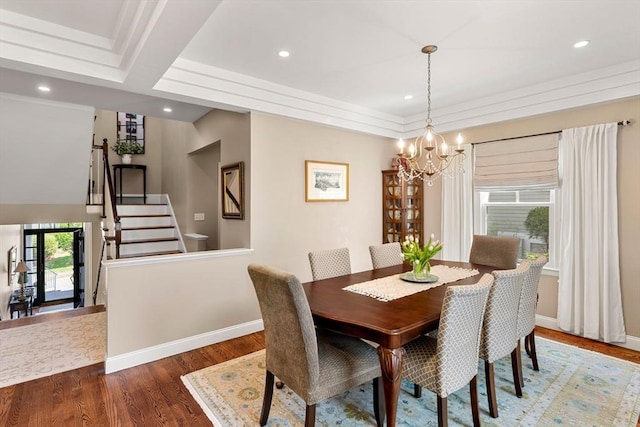 dining area featuring baseboards, stairs, wood finished floors, and a chandelier