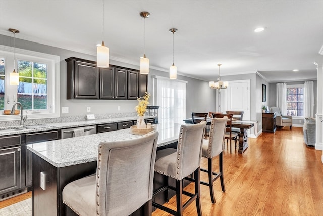 kitchen featuring pendant lighting, a kitchen bar, plenty of natural light, and a kitchen island