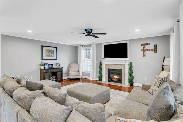 living room featuring ceiling fan, light hardwood / wood-style floors, and crown molding