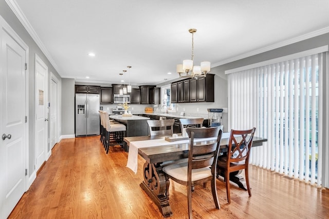 dining room with a wealth of natural light, a notable chandelier, crown molding, and light hardwood / wood-style flooring