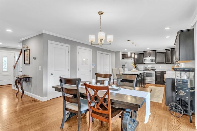 dining area featuring ornamental molding, light wood-type flooring, and a chandelier