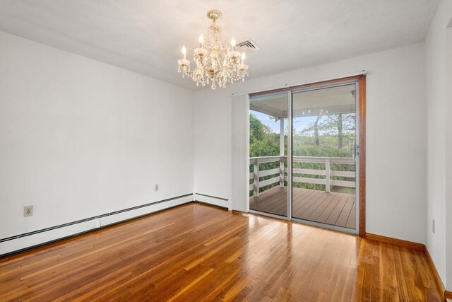 unfurnished room featuring a chandelier, baseboard heating, wood finished floors, and baseboards