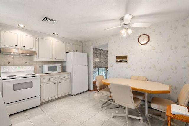 kitchen featuring white appliances, under cabinet range hood, wallpapered walls, light countertops, and a ceiling fan