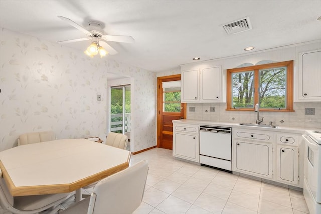 kitchen featuring white appliances, a sink, wallpapered walls, light countertops, and a ceiling fan