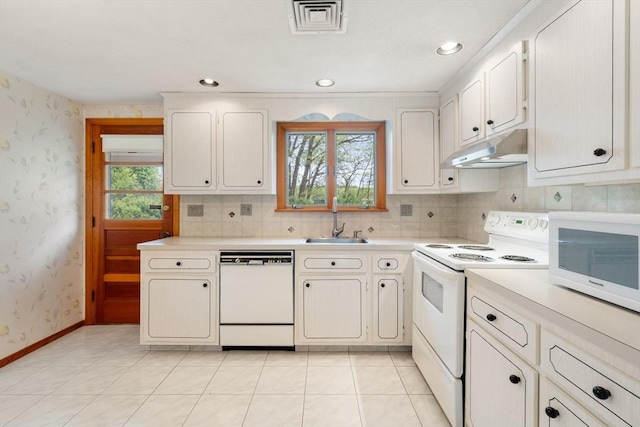 kitchen featuring white appliances, under cabinet range hood, wallpapered walls, light countertops, and a sink