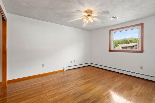 empty room with baseboard heating, light wood-type flooring, ceiling fan, and baseboards