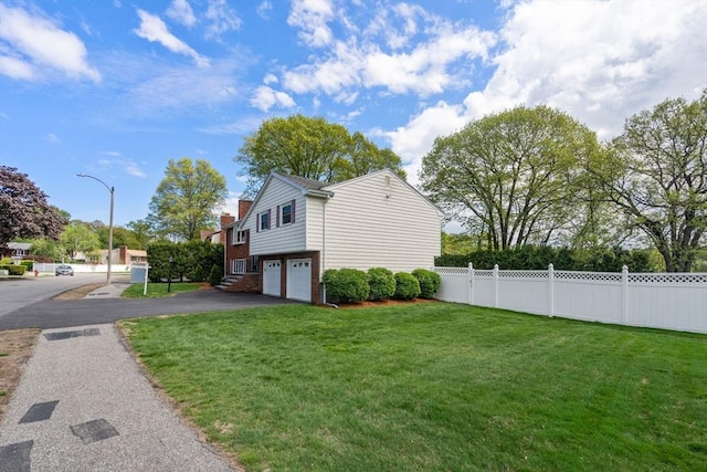 view of home's exterior with an attached garage, asphalt driveway, and brick siding