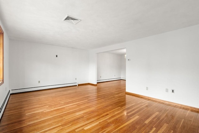 empty room with a baseboard radiator, light wood-type flooring, baseboard heating, and baseboards