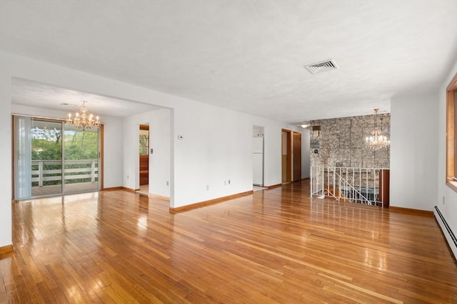 unfurnished living room with a chandelier, light wood-type flooring, and baseboards