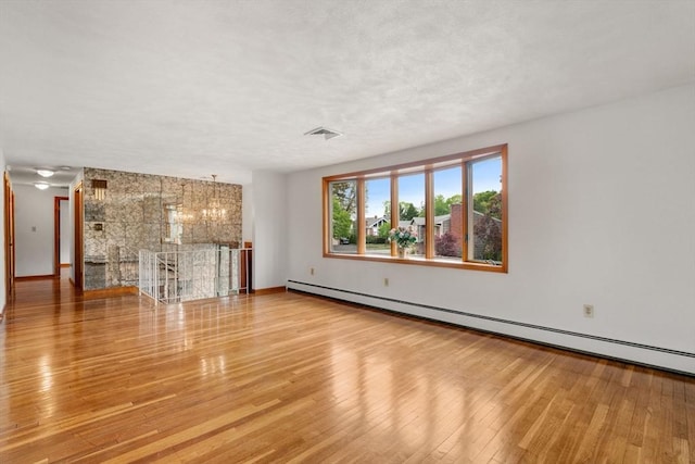 unfurnished living room with a baseboard radiator, hardwood / wood-style floors, and baseboards
