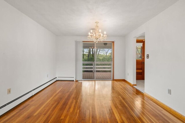spare room featuring wood-type flooring, a chandelier, a baseboard radiator, baseboards, and a baseboard heating unit