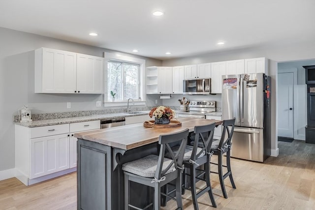 115 Kiahs Way, Sandwich, MA 02537 - kitchen featuring appliances with stainless steel finishes, a sink, white cabinetry, a kitchen bar, and recessed lighting