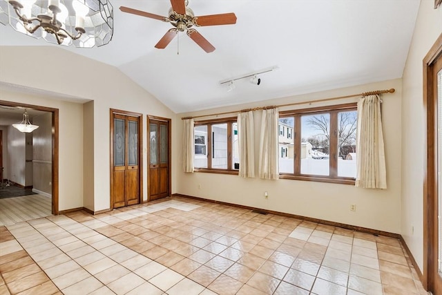 tiled empty room featuring ceiling fan with notable chandelier and lofted ceiling