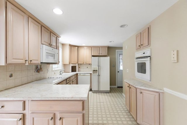 kitchen featuring backsplash, white appliances, kitchen peninsula, and light brown cabinets