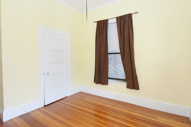 spare room with wood-type flooring and ornamental molding