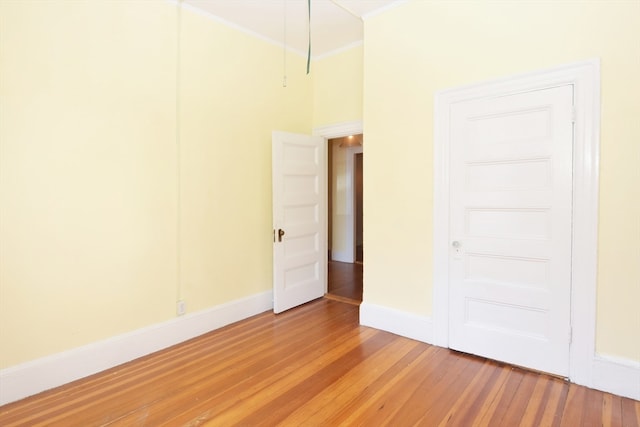 unfurnished bedroom with hardwood / wood-style floors and ornamental molding