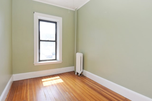 spare room with light wood-type flooring and radiator heating unit