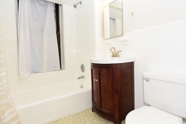 full bathroom with shower / tub combo, toilet, tile patterned floors, tile walls, and vanity