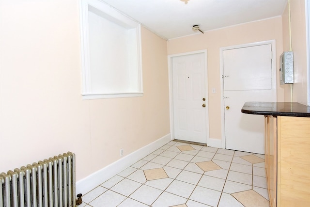 entryway with light tile patterned flooring and radiator heating unit