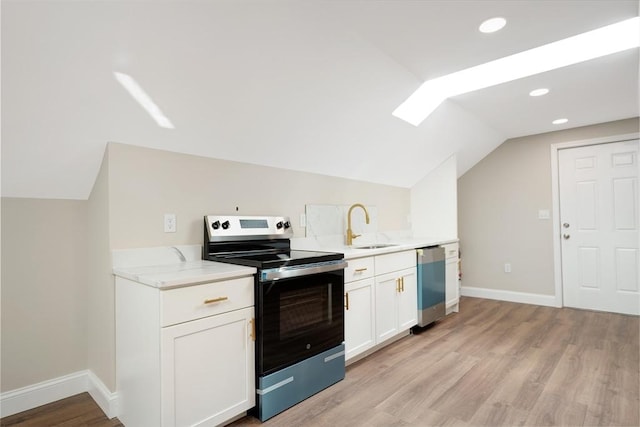41 Adams St, Fairhaven, MA 02719 - kitchen with appliances with stainless steel finishes, lofted ceiling, light wood-type flooring, white cabinets, and recessed lighting