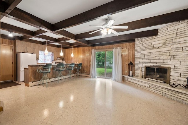 181 Thayer Farms Rd, Attleboro, MA 02703 - kitchen with freestanding refrigerator, beamed ceiling, a fireplace, wooden walls, and ceiling fan