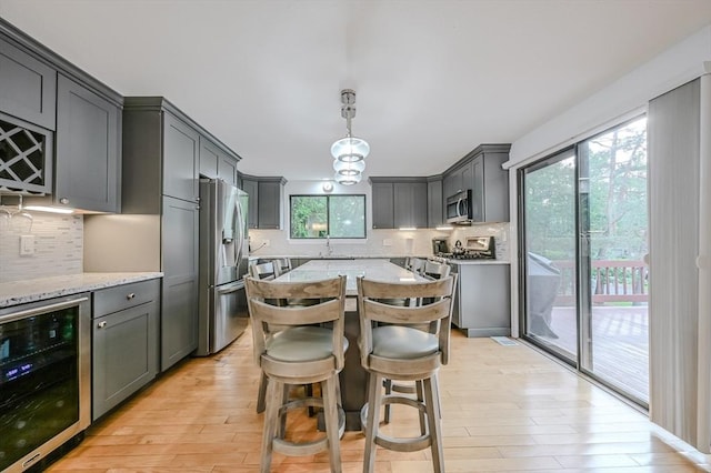 9 Country Club Ln Unit A, Milford, MA 01757 - kitchen featuring wine cooler, appliances with stainless steel finishes, decorative backsplash, and light stone countertops
