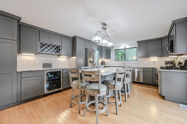 9 Country Club Ln Unit A, Milford, MA 01757 - kitchen with beverage cooler, stainless steel appliances, tasteful backsplash, and a kitchen island