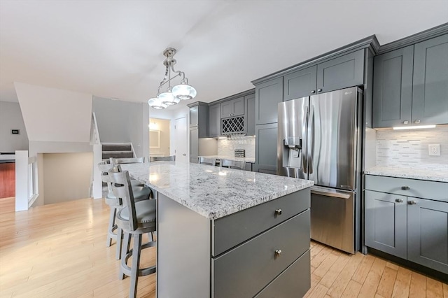 9 Country Club Ln Unit A, Milford, MA 01757 - kitchen with stainless steel fridge, light wood-type flooring, light stone countertops, and a center island