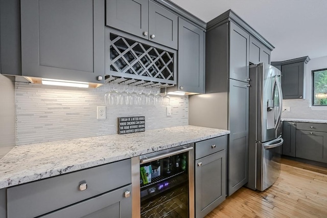 9 Country Club Ln Unit A, Milford, MA 01757 - kitchen featuring wine cooler, stainless steel fridge, gray cabinetry, decorative backsplash, and light stone countertops