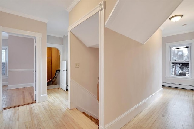 hallway with baseboard heating, light wood-type flooring, and crown molding