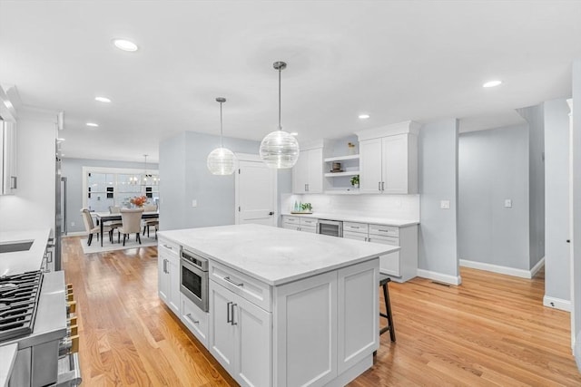 kitchen featuring white cabinetry, a kitchen island, light wood-style flooring, and open shelves