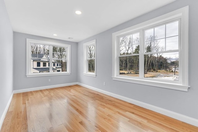 spare room with recessed lighting, baseboards, and wood finished floors