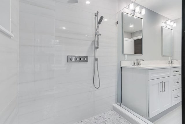 full bathroom with a sink, double vanity, and tiled shower