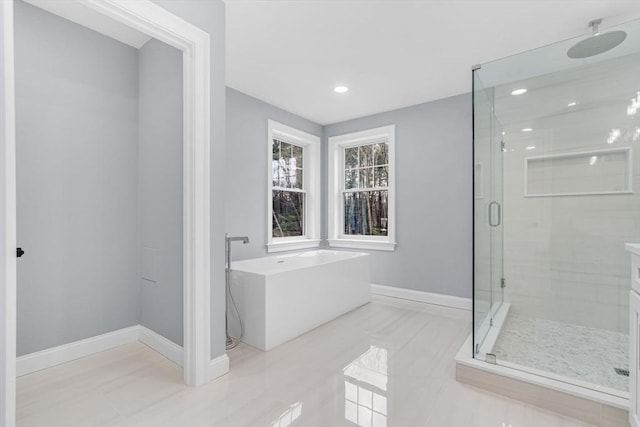 full bath featuring a freestanding tub, tile patterned flooring, recessed lighting, baseboards, and a stall shower