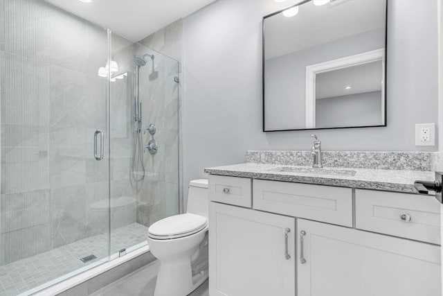 full bathroom featuring toilet, a shower stall, and vanity