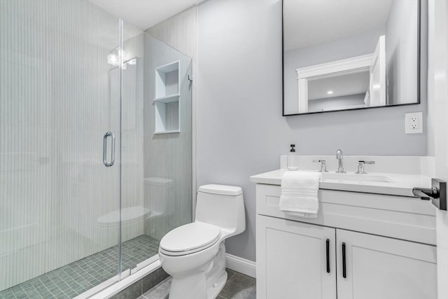 bathroom with toilet, vanity, baseboards, a shower stall, and tile patterned floors