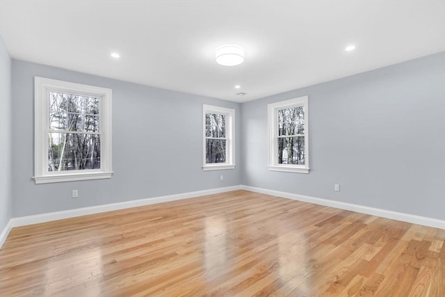 unfurnished room with light wood-type flooring, baseboards, and recessed lighting