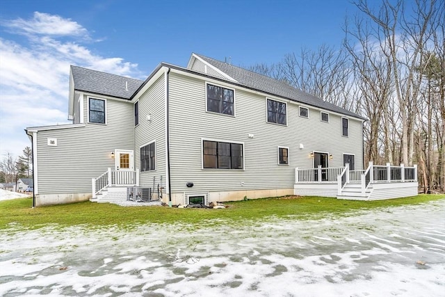 back of property with central AC and roof with shingles