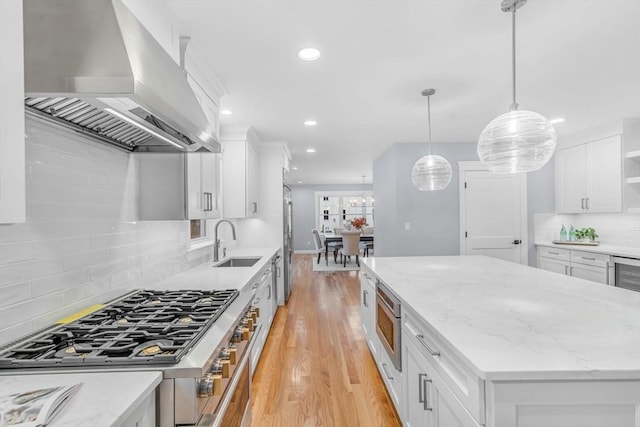 kitchen with light wood finished floors, white cabinets, stainless steel appliances, open shelves, and exhaust hood