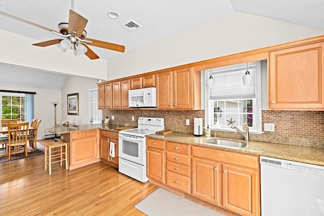 11 Quashnet Woods Dr, Mashpee, MA 02649 - kitchen with white appliances, vaulted ceiling, light wood-type flooring, a peninsula, and backsplash