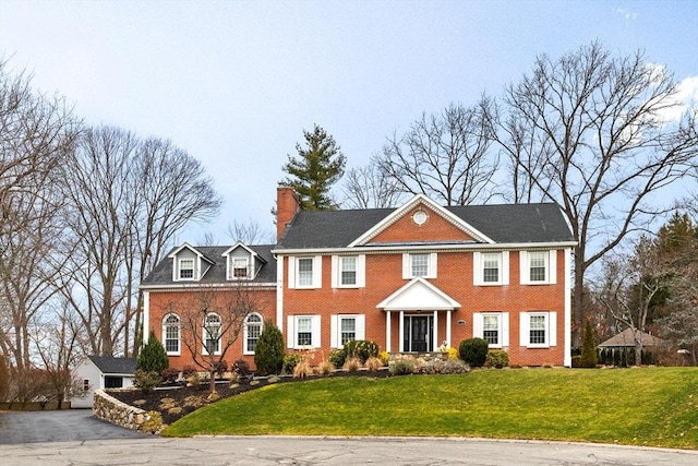 colonial-style house featuring a front yard