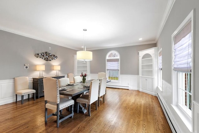 dining room featuring hardwood / wood-style floors, ornamental molding, and a baseboard radiator