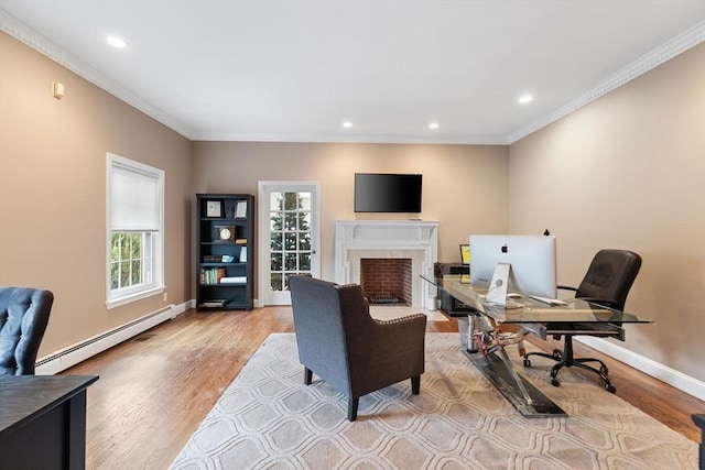 home office with crown molding, light wood-type flooring, and a baseboard heating unit