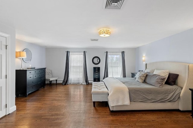 bedroom featuring a baseboard heating unit and dark wood-type flooring