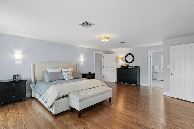 bedroom with hardwood / wood-style flooring and connected bathroom