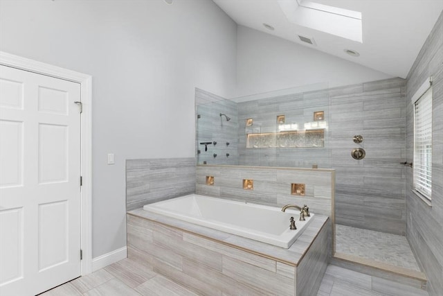 bathroom with plus walk in shower, a skylight, and high vaulted ceiling