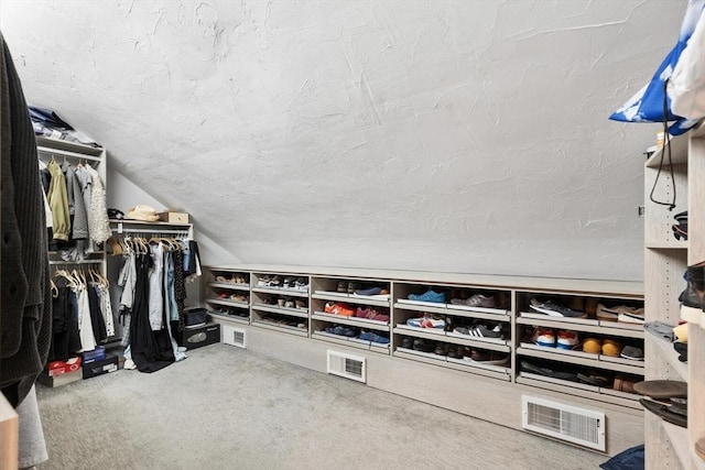 walk in closet featuring carpet floors and vaulted ceiling